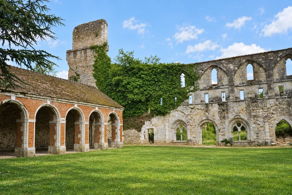 The ruins of Abbaye de Mortemer among the trees