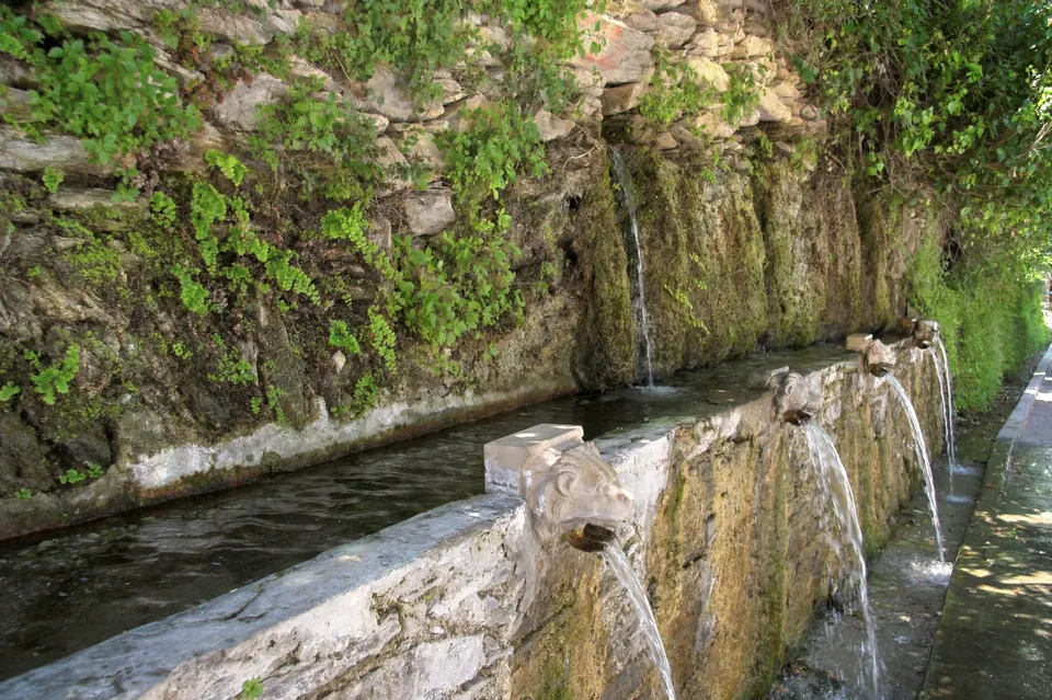 The spouts in the wall, running under the plane trees