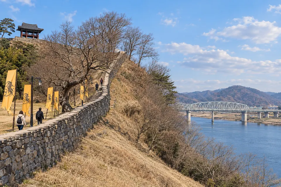 Gongsanseong's walls and flags above the Geum River