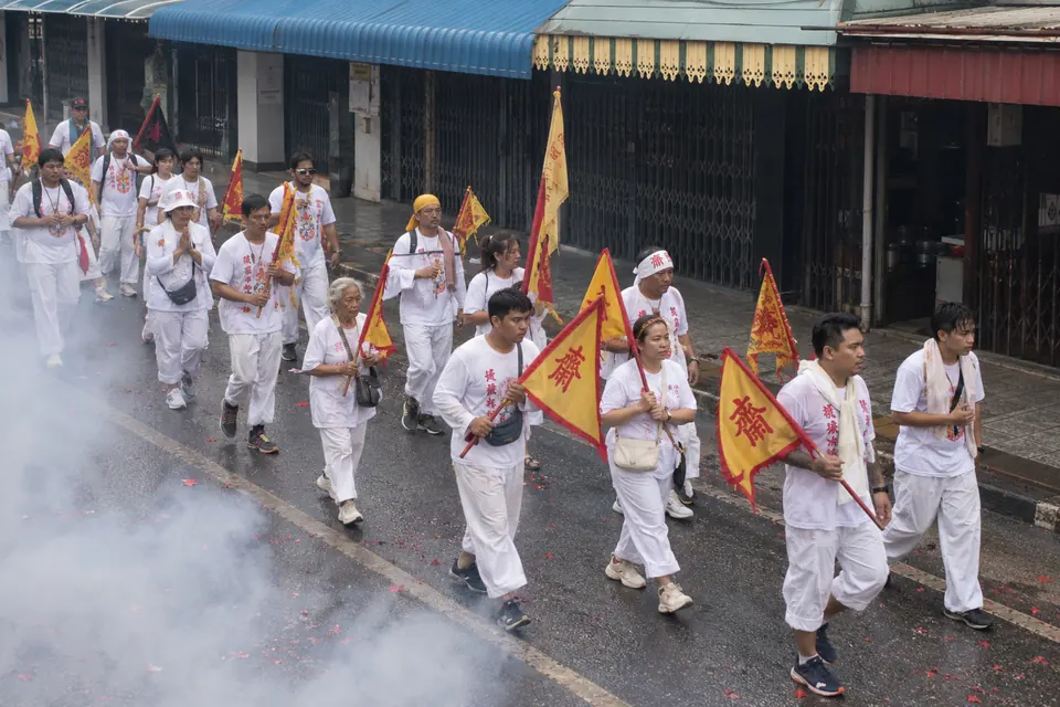 Vegetarian Festival procession, devotees in white and firecracker smoke