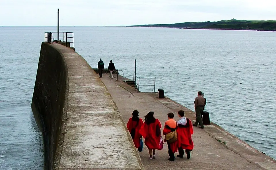 Students in red gowns on the Sunday pier walk
